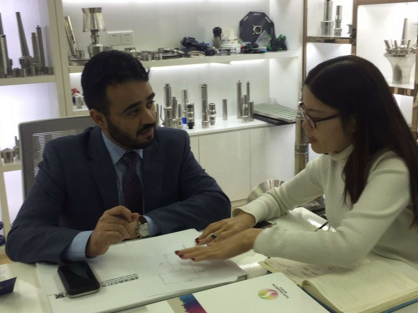 Business discussion with technical documents.